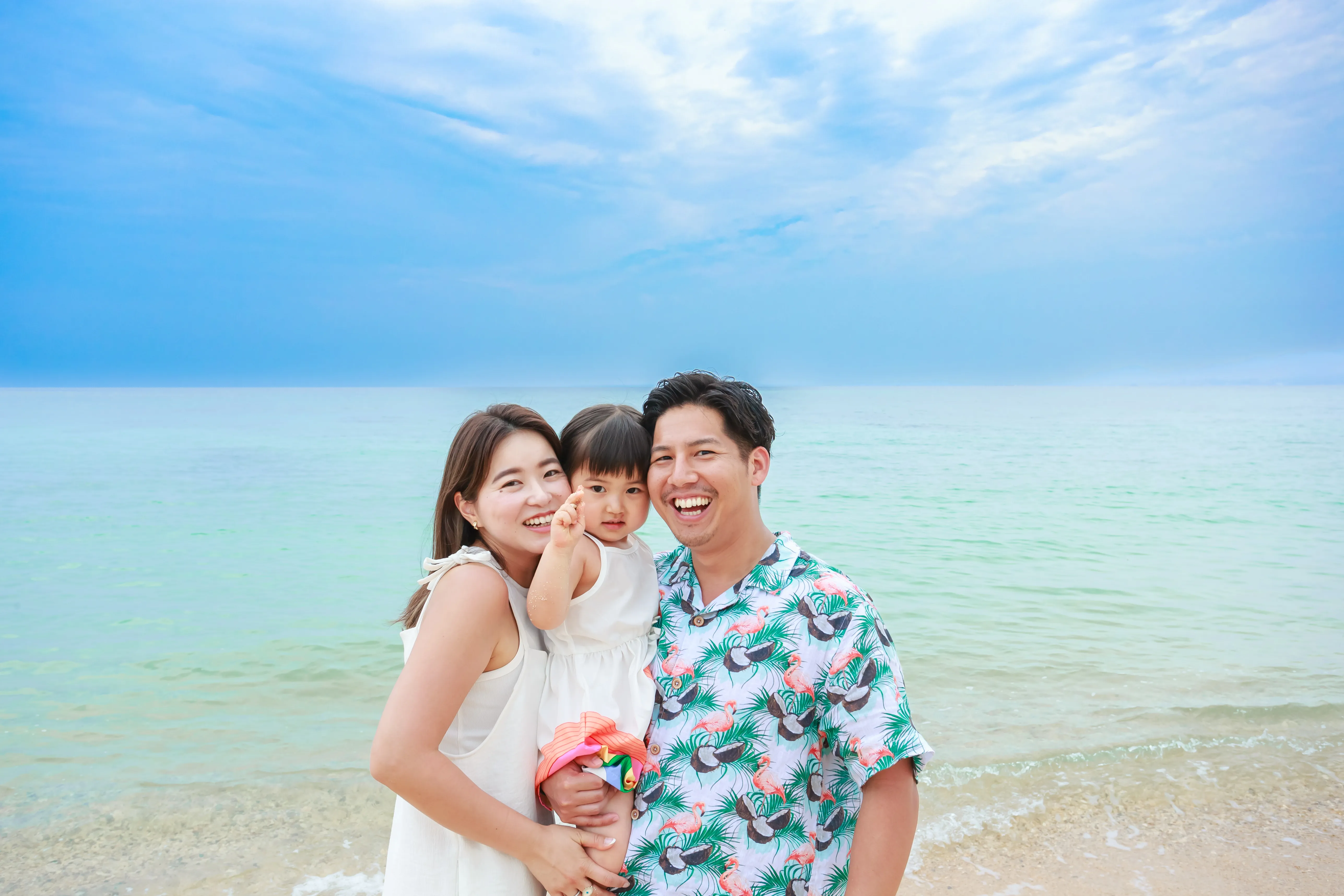 安富祖ビーチ ファミリーフォト 青い海を背景に笑顔の家族