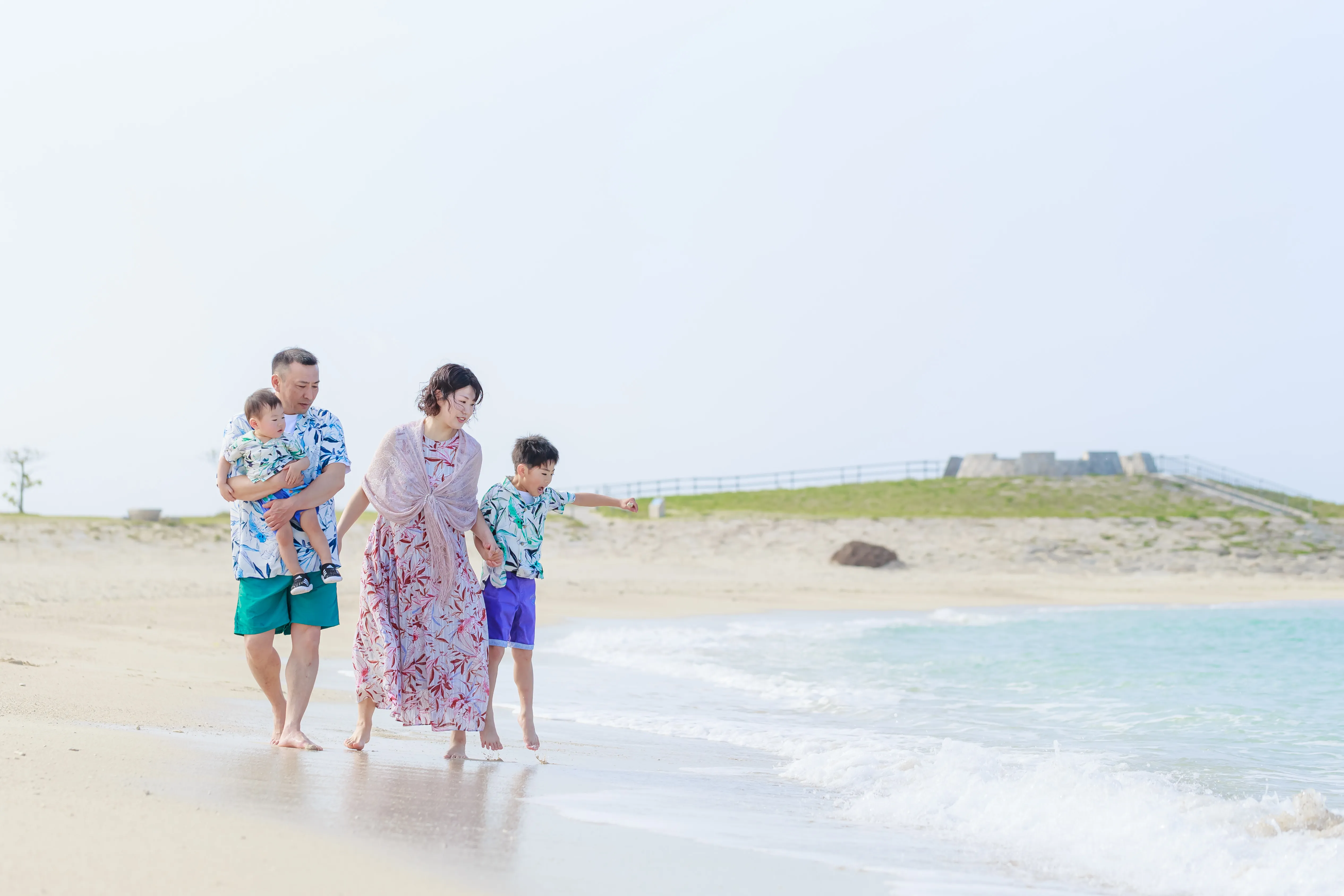 北名城ビーチの向こうに見える無人島を指差す子ども
