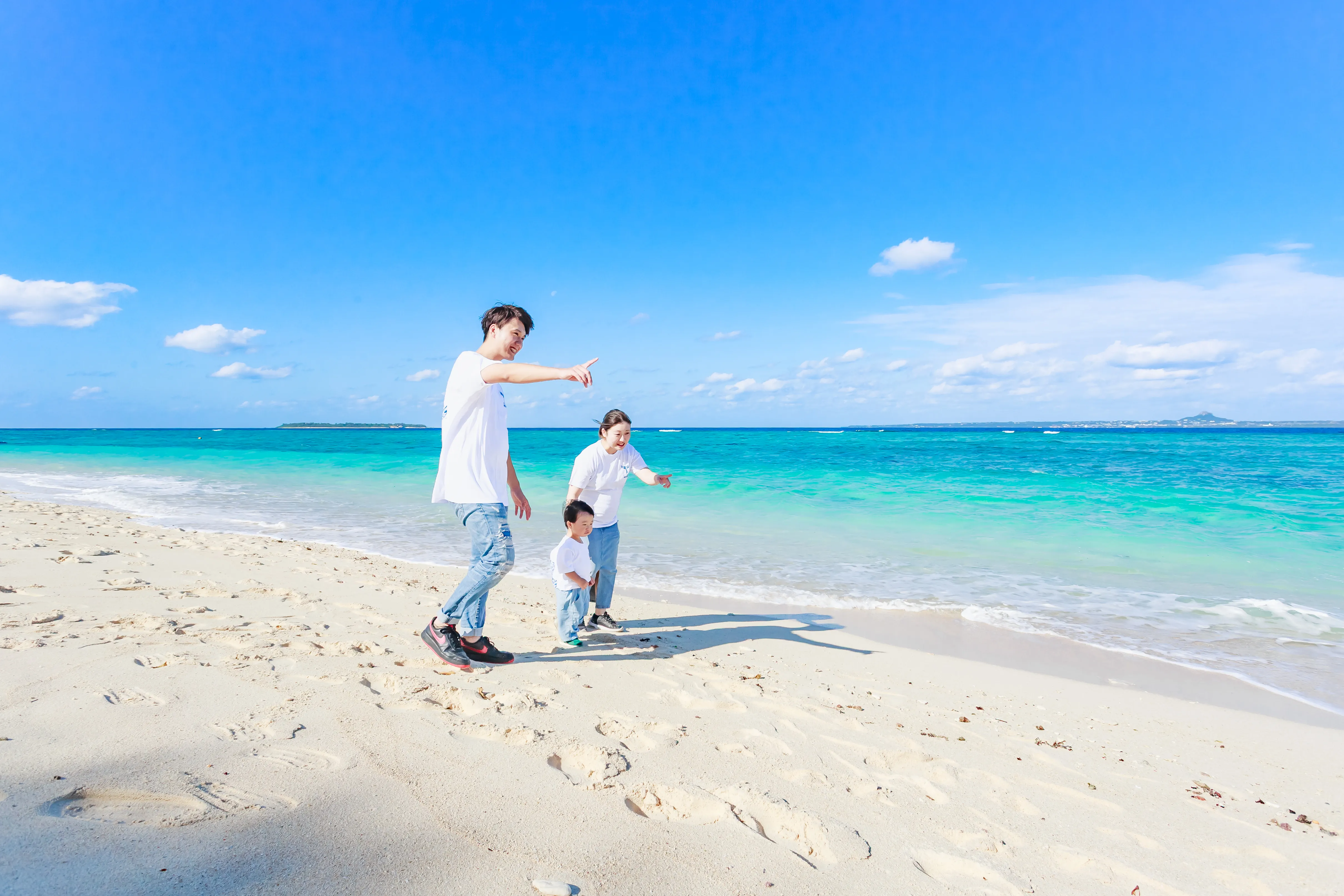 瀬底ビーチの圧倒的に透き通った海で水遊びする子どもたち